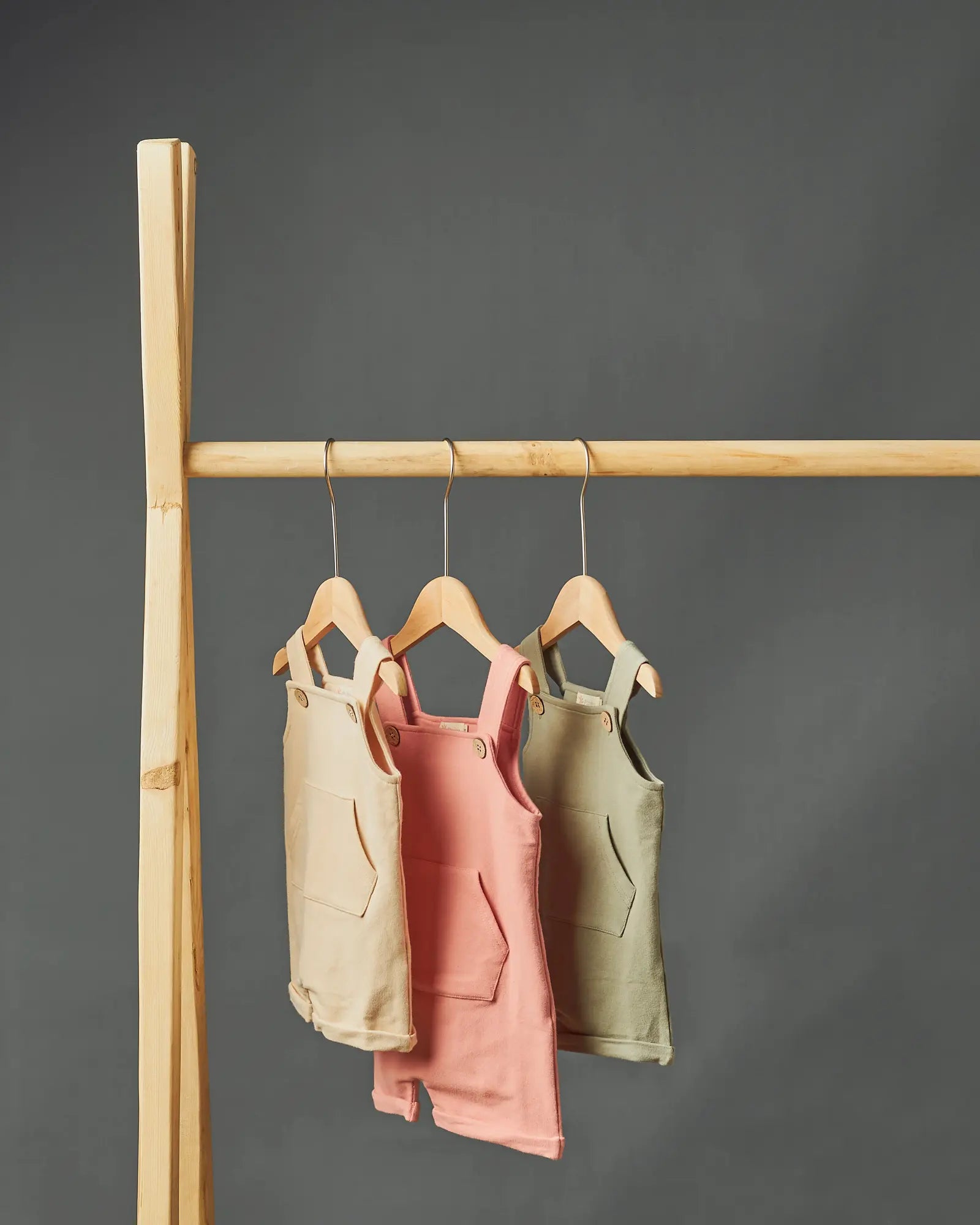 TUSO organic cotton baby overall with coconut shell buttons hanging on a rack| Paalm Baby Clothing Nigeria